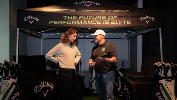 Two people talking under a Callaway canopy.
