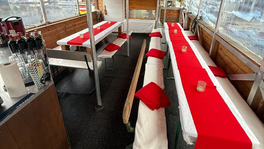 Tables set with red cloths and candles inside.