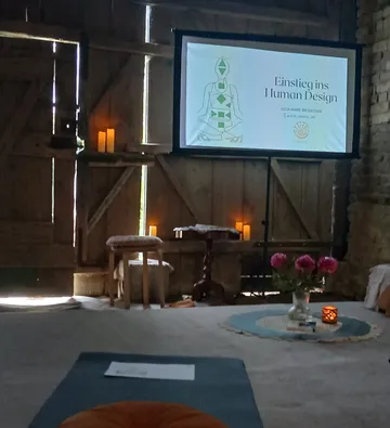 Projector displays human design chart in rustic room.