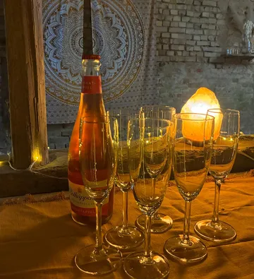 Bottle and glasses on a decorated table.