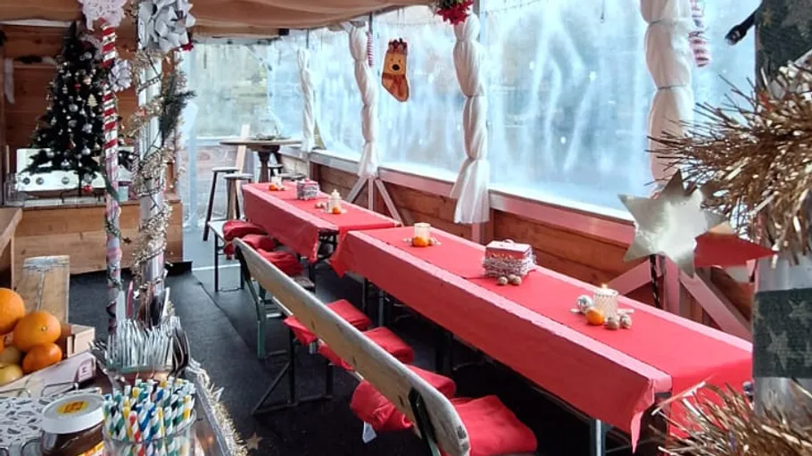 Festlich dekorierter Raum mit Tischen und Stühlen.