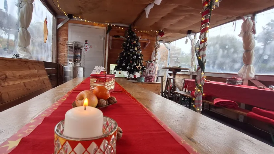 Kerze auf Tisch, geschmückter Weihnachtsraum.