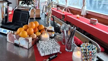 Table with oranges, waffle maker, Nutella jar.