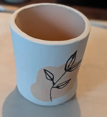 Dekorativer Keramikbecher mit Blumenmuster.