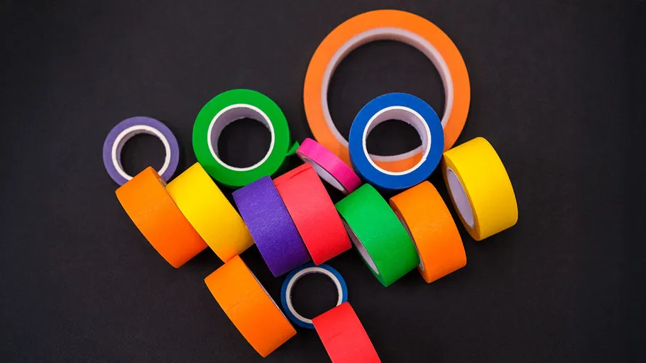 Bunte Klebebandrollen auf schwarzem Hintergrund.