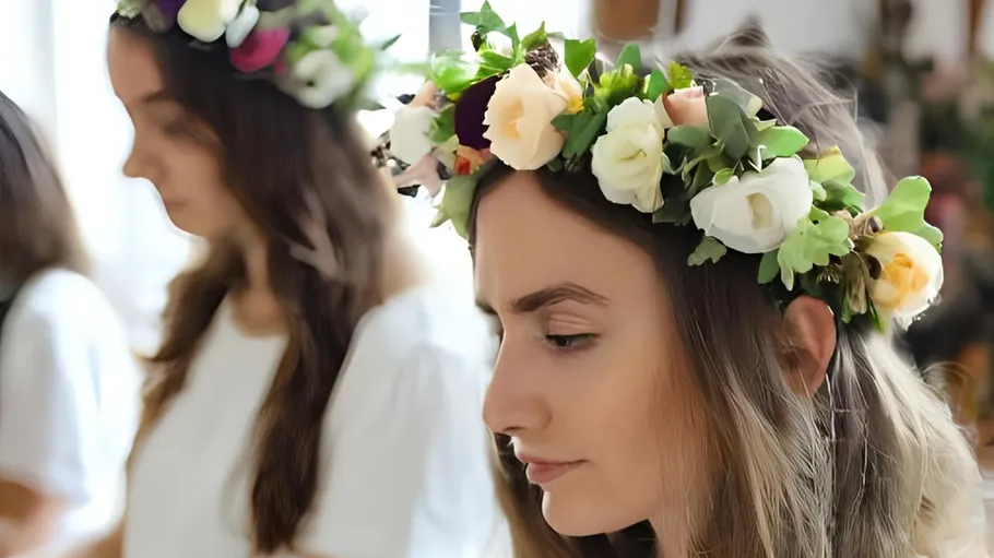Zwei Frauen tragen Blumenkränze drinnen.