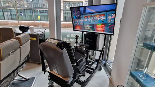 Flugsimulator-Aufbau mit Bildschirm im Innenbereich.