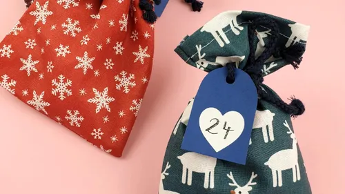 Two festive cloth bags with drawn tags.