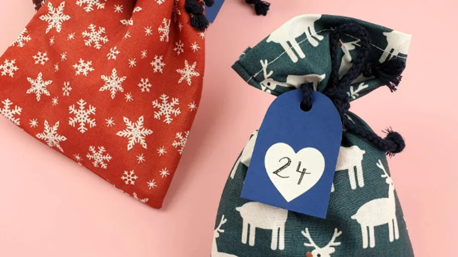 Two festive cloth bags with drawn tags.