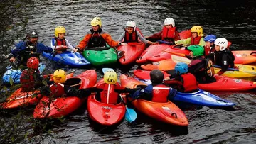 Gruppe von Kajakfahrern auf einem Fluss.