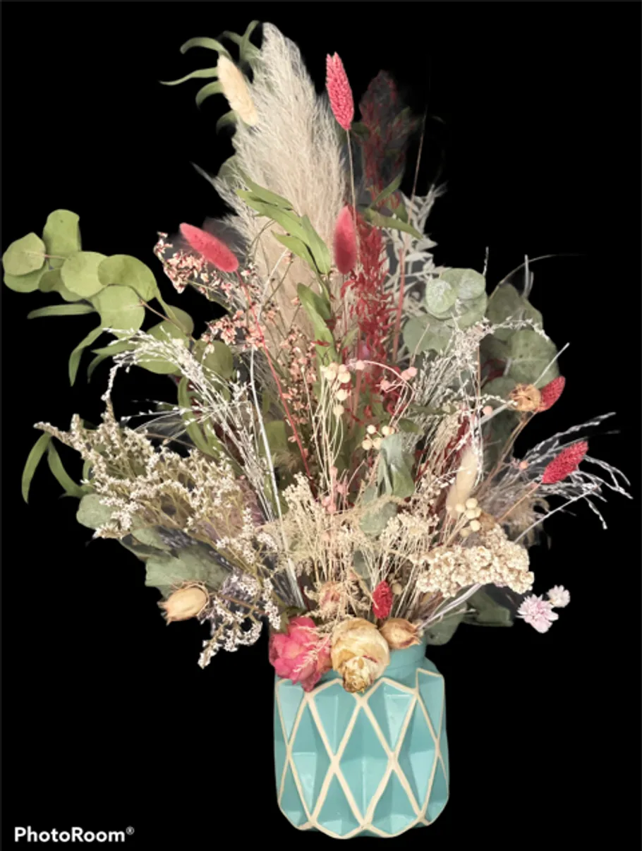 Dried flower bouquet in turquoise vase, black background.