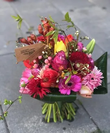 Colorful flower bouquet on pavement.