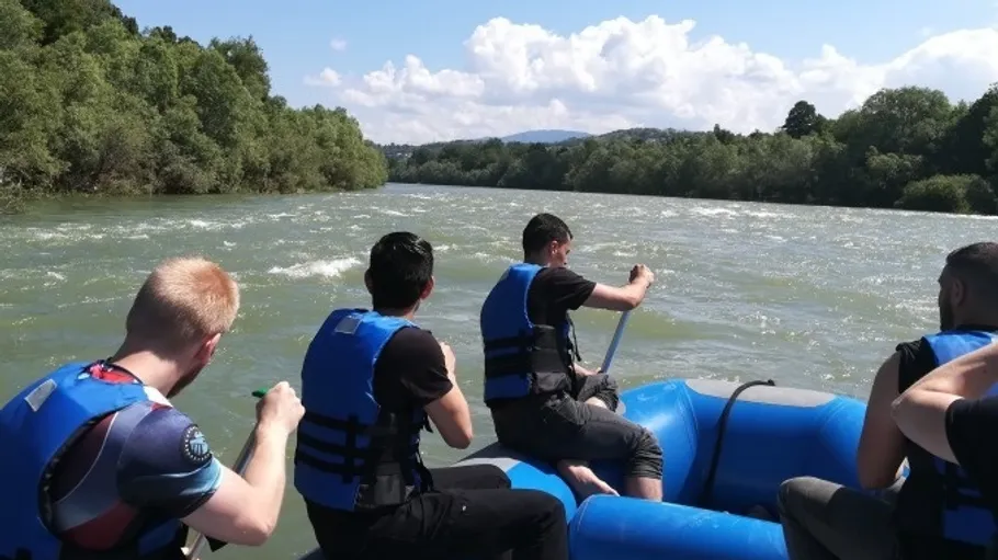 Gruppe beim Rafting auf einem Fluss in der Natur.