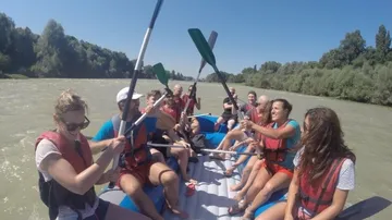 People rafting on a river in sunny weather.