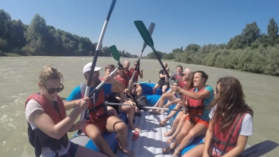 Menschen raften auf einem Fluss bei Sonnenschein.