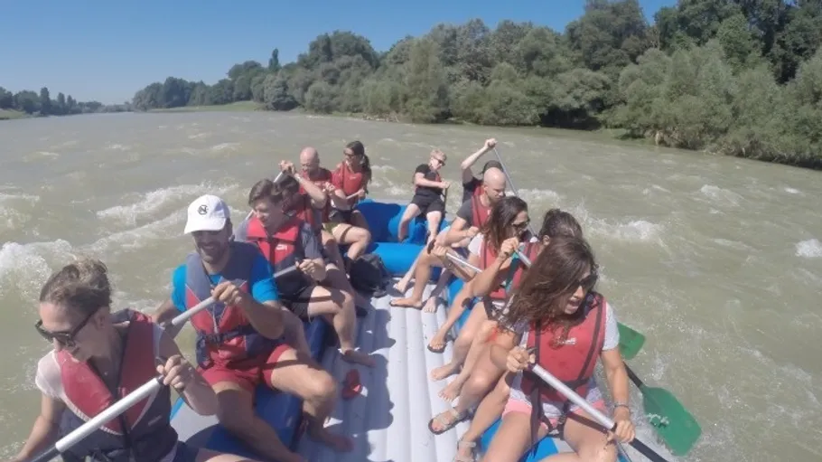 Gruppe beim Rafting auf einem sonnigen Fluss.
