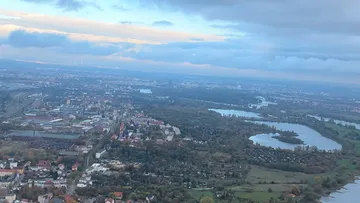 Aerial view of city with river and clouds.
