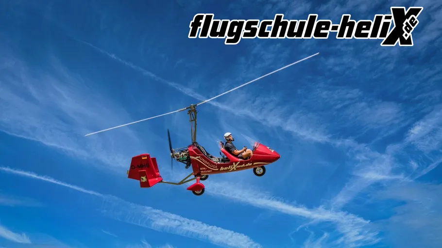 Rotes Gyroplane fliegt vor blauem Himmel.