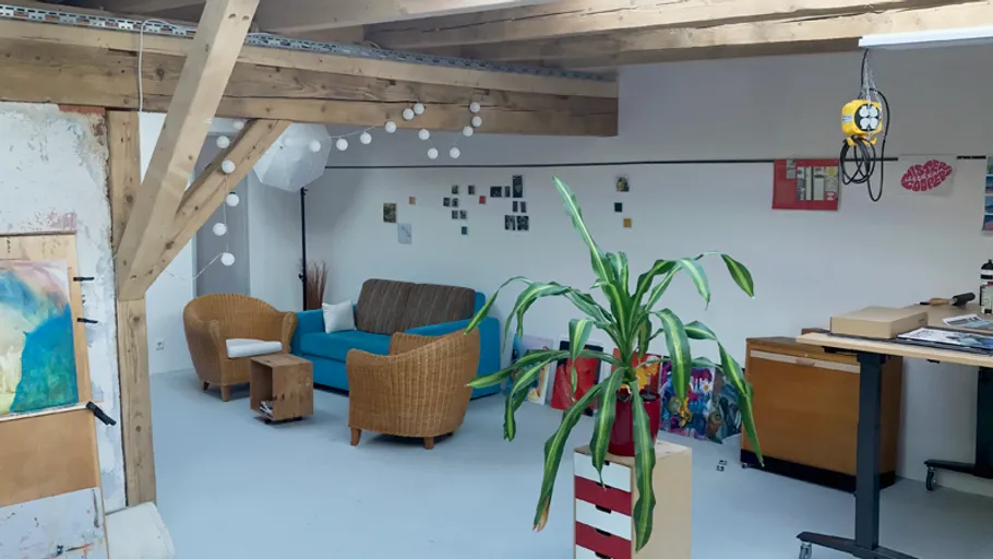 Gemütliches Studio mit Pflanzen und Holzbalken.