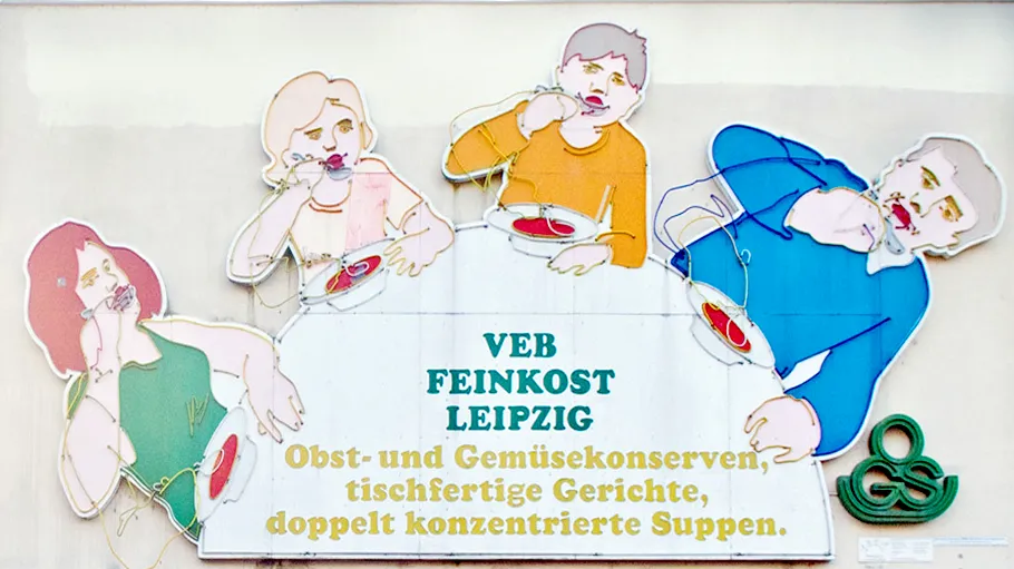 Neonschild mit Menschen beim Suppeessen.