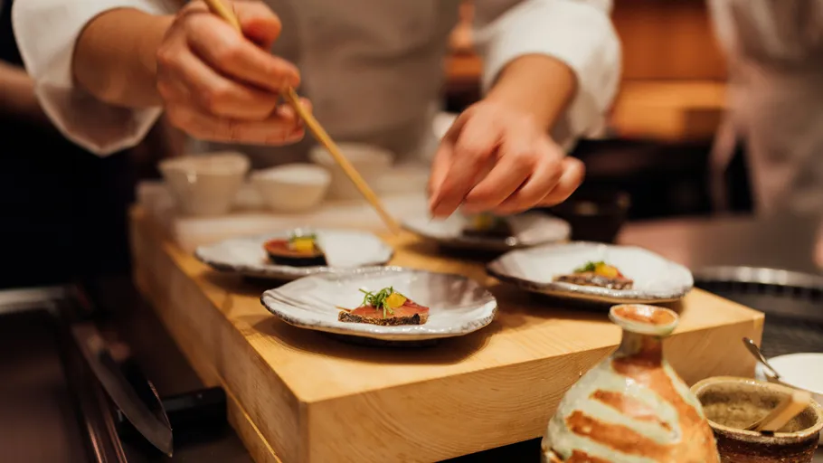 Chef plating food in restaurant kitchen.