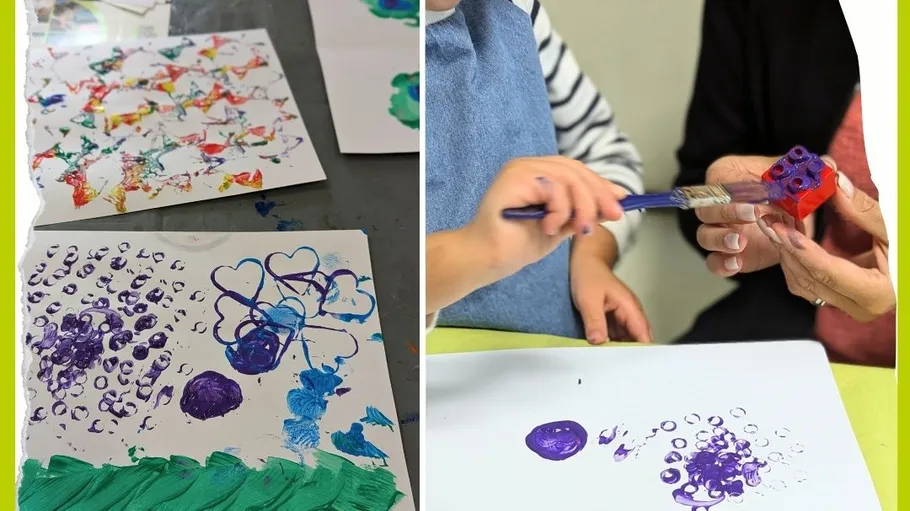 Child painting with Lego and brush.