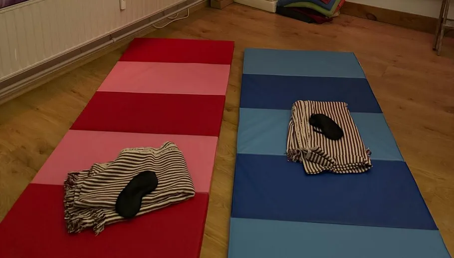 Red and blue mats with blankets and masks.