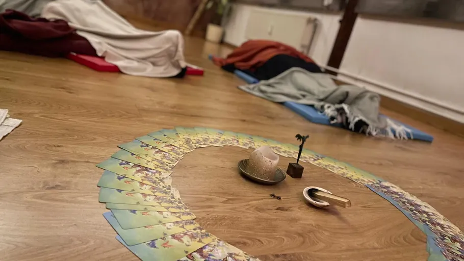 Blanket-covered people lying on floor with cards.