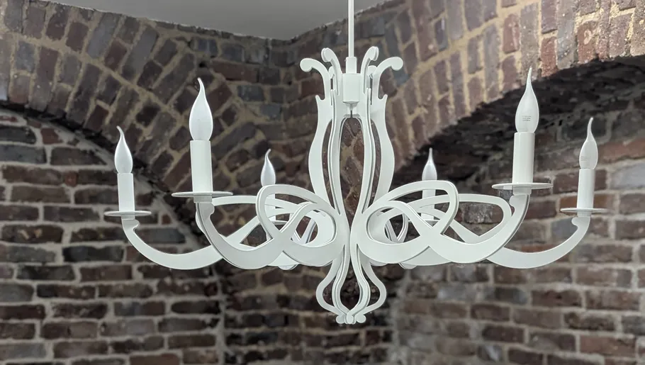 White chandelier hanging in brick room.