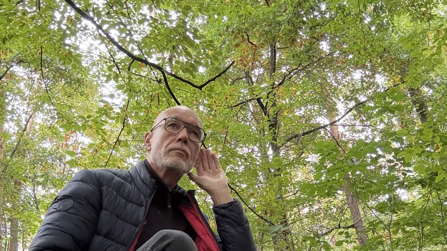 Man listening in a forest environment.