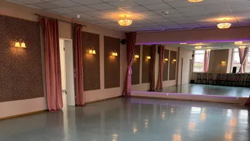 Leeres Tanzstudio mit Spiegeln und Kronleuchtern.