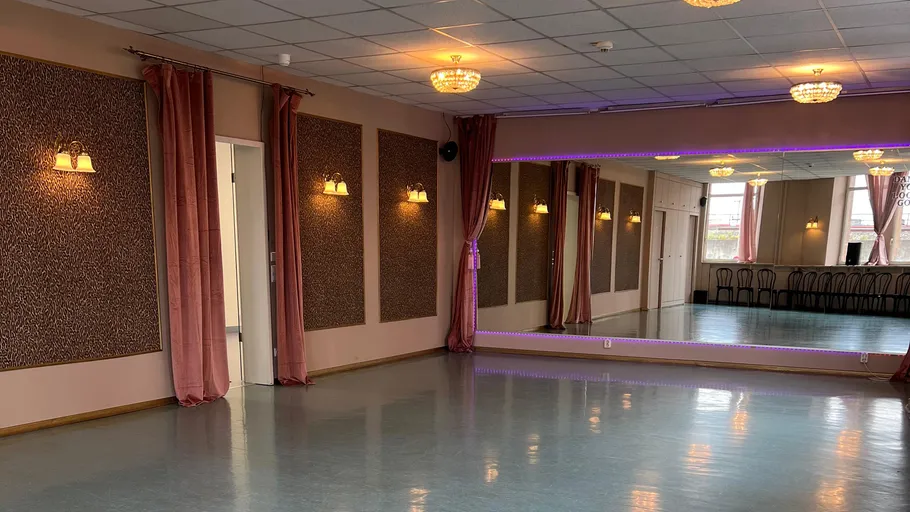Empty dance studio with mirrors and chandeliers.