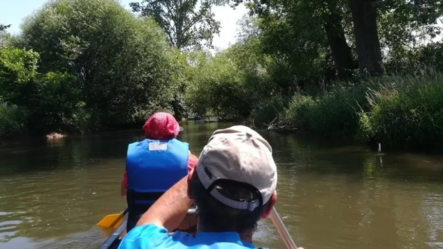Zwei Personen paddeln auf einem Fluss.