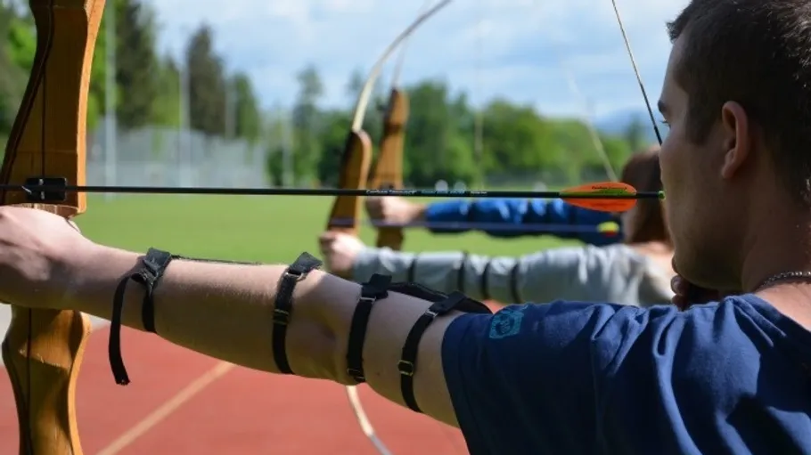 People bow shooting on an outdoor range.