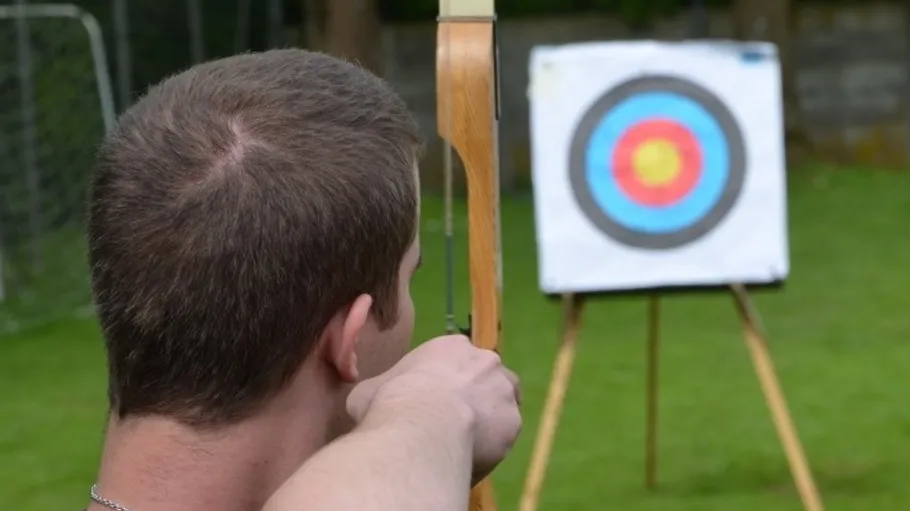 Archer aiming at a target outdoors.