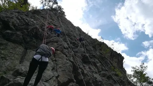 People climbing a steep rock face outdoors.