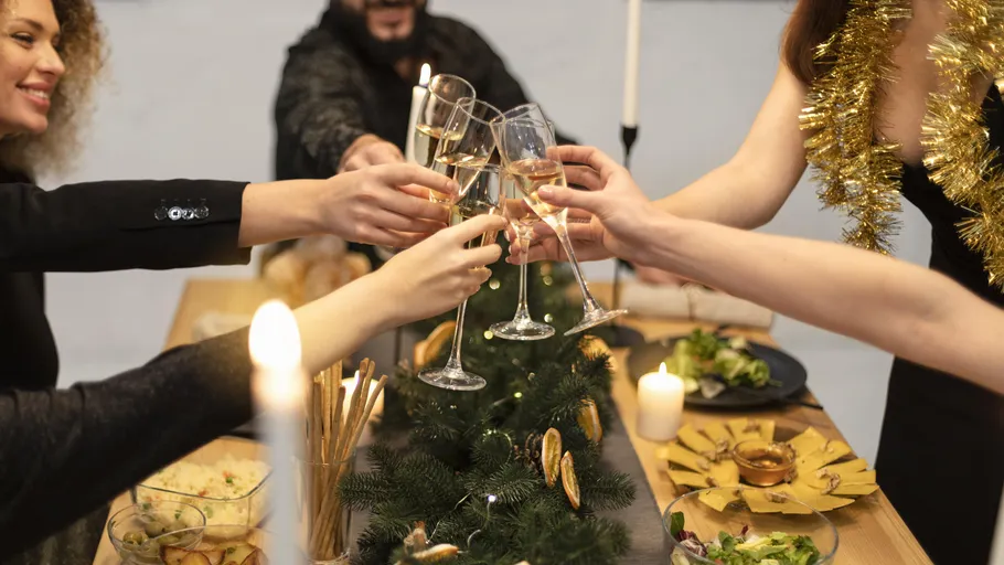 People clinking glasses at festive table.