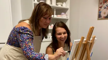 Two women painting together indoors.