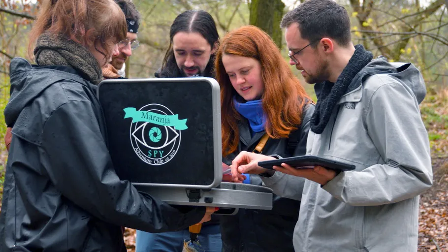 Gruppe untersucht Laptop im Wald draußen.