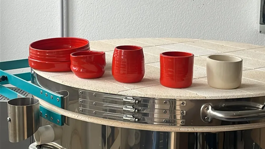 Five clay pots cooling on kiln lid.