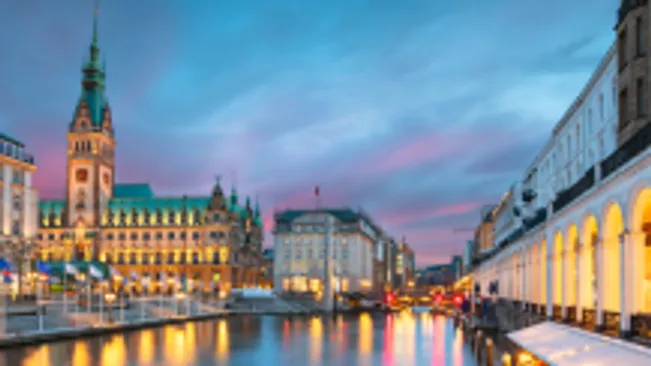 Historic buildings reflected in city canal at dusk.