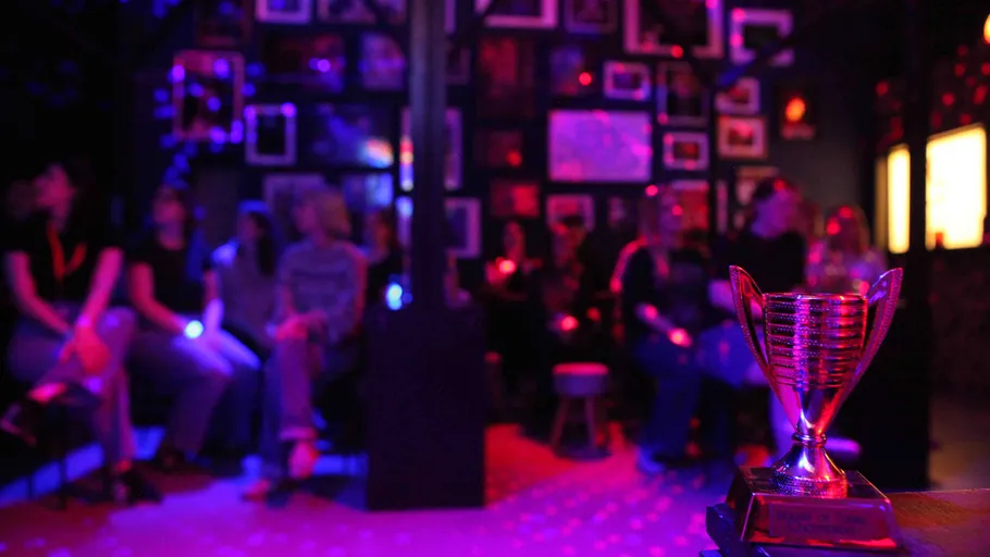 Trophy displayed in dimly lit room with seated people.