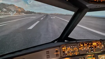 Cockpit simulator showing runway view.