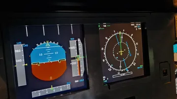 Aircraft cockpit display showing flight instruments.