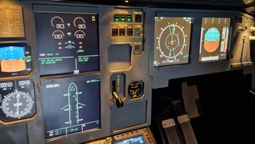 Aircraft cockpit with various control panels.