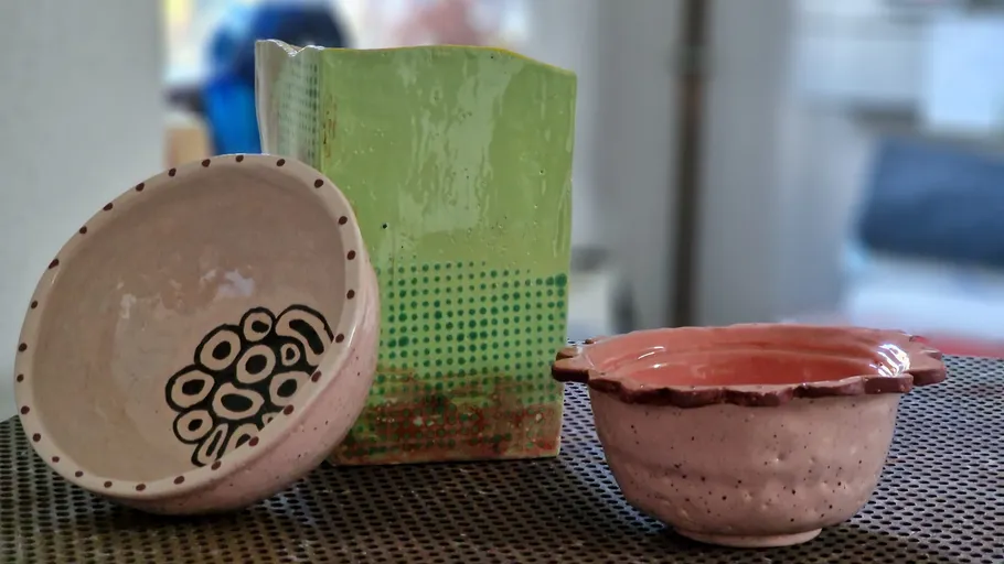 Three ceramic bowls on a metal surface.