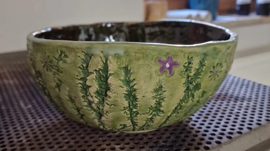 Keramikschüssel mit Blattdesign auf Matte.