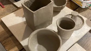 Clay pottery pieces on a wooden table.