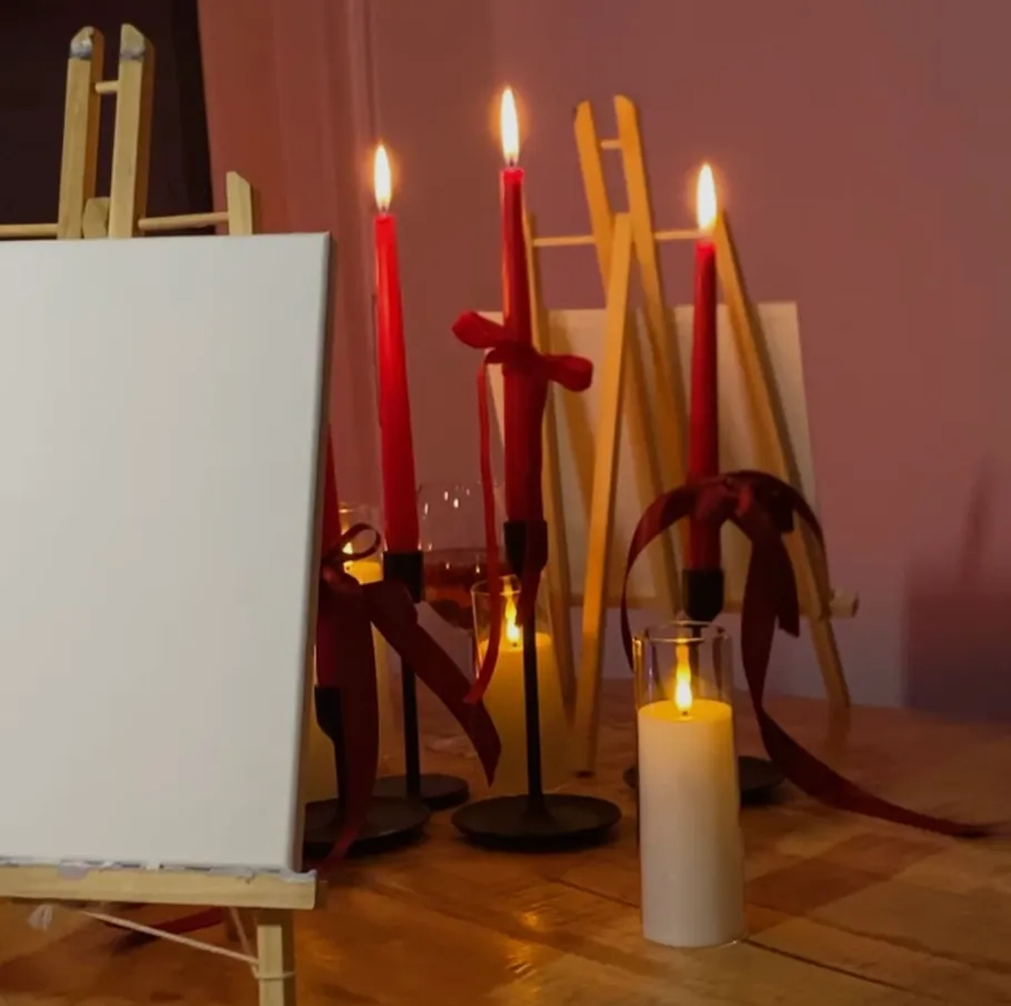 Blank canvas and lit candles on table.