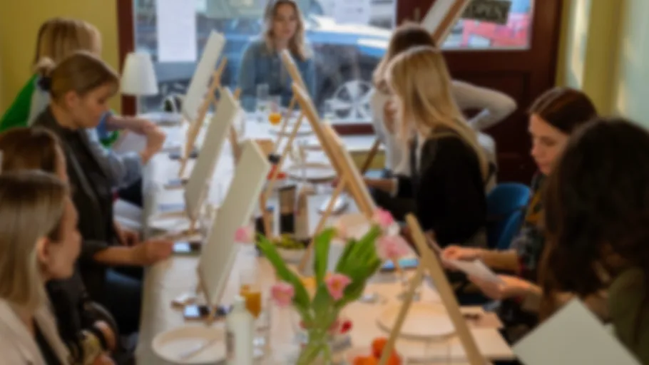 People painting on canvases in a bright room.